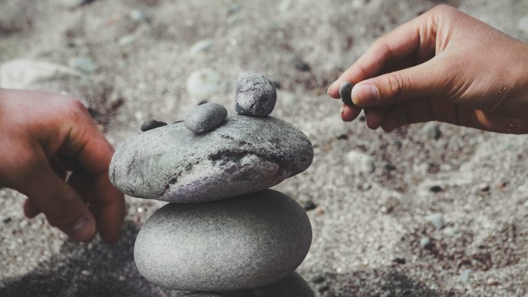 People building a structure out of rocks and pebbles